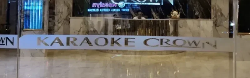 대리석 로비의 KARAOKE CROWN 입구 간판과 카운터